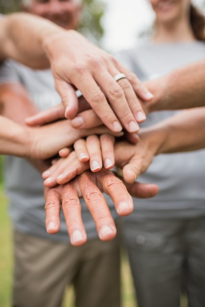 Happy volunteer family putting their hands together 