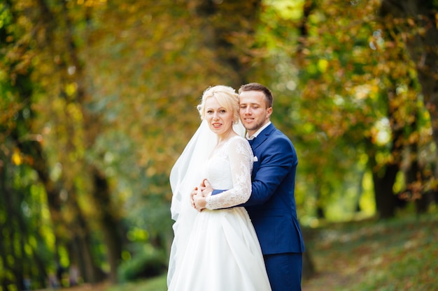 Happy wedding couple walking in the park