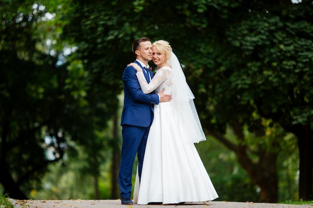 Happy wedding couple walking in the park