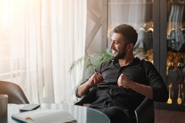 Happy wine business owner sitting in front of an open notebook