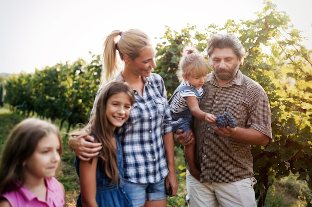 Happy winegrower family in vineyard before harvesting