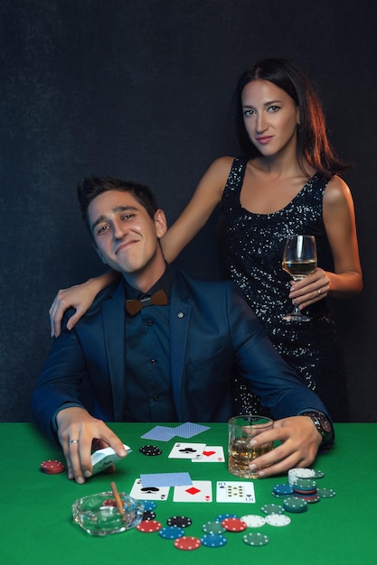 Happy winning poker player with poker cards and chips in casino