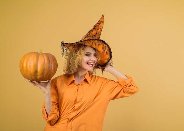 Happy witch with pumpkin costume and witch hat halloween concept woman dressing in halloween costume