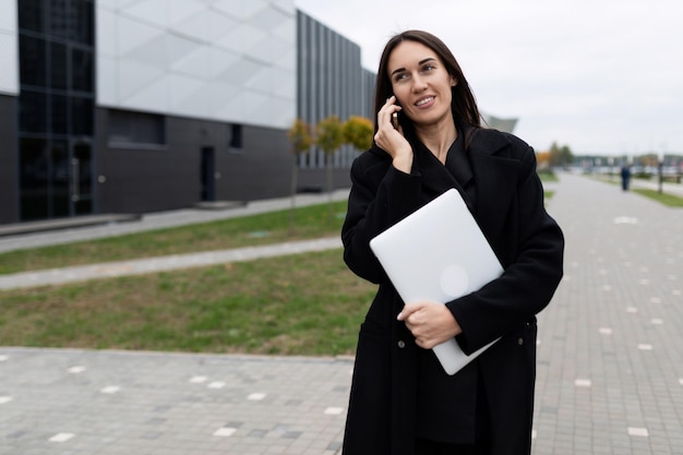 Happy woman architect discussing construction details on the phone against the backdrop of an elite