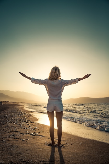 happy woman at the beach at sunset