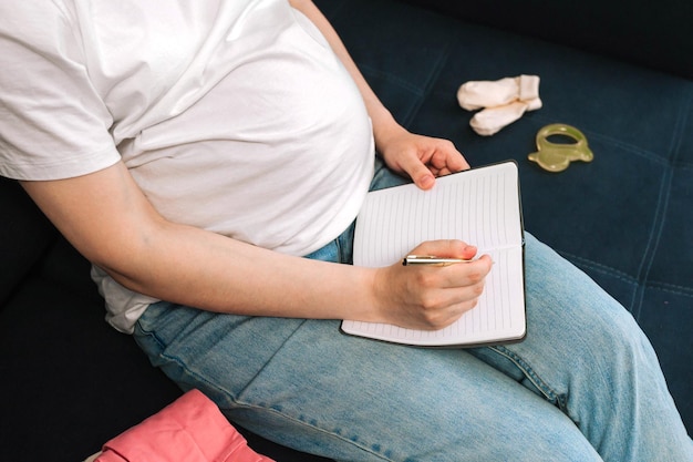 Happy woman collects things for newborns in bag fees in the hospital