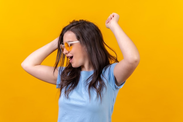 Happy woman dancing and celebrating raising arms