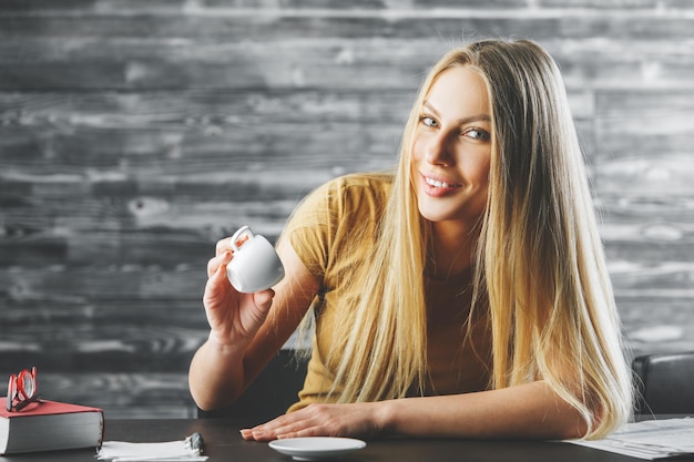 Happy woman drinking coffee at work