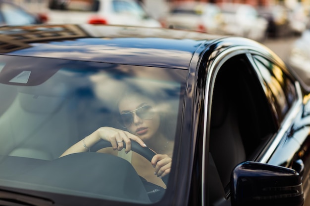 Happy woman driver at car smiling Cute young happy brunette female driving car vehicle