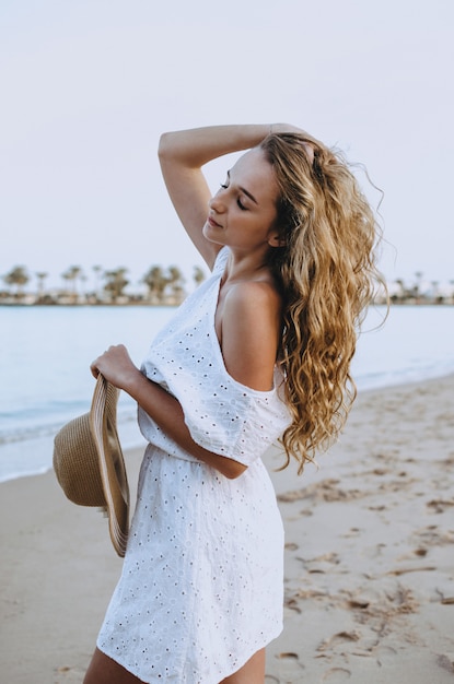 Happy woman enjoying beach relaxing joyful in summer by tropical blue water