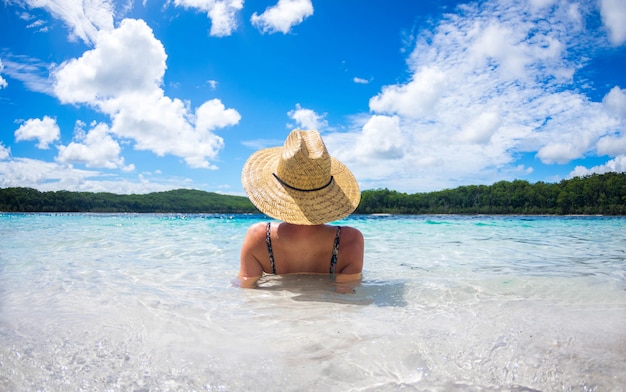 Photo happy woman enjoying beach relaxing joyful in summer by tropical blue water.