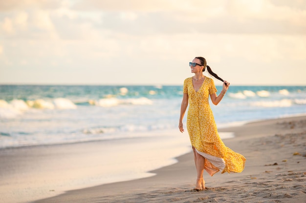 Happy woman enjoying beautiful sunset on the beach