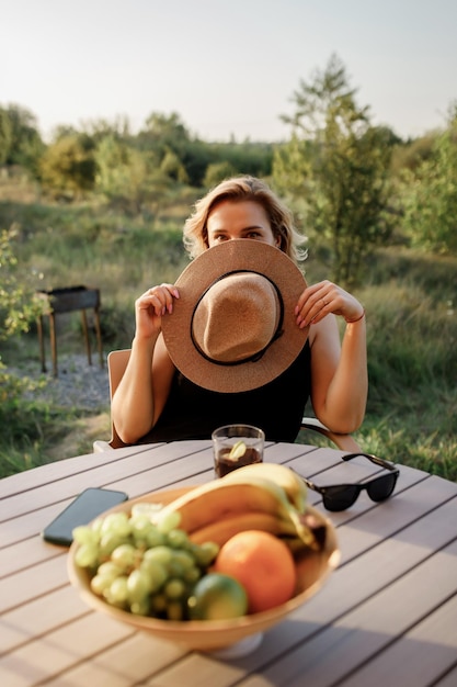 Happy Woman freelancer drinking cocktail and relaxing on cozy glamping tent in sunny day Luxury camping tent for outdoor summer holiday and vacation Lifestyle concept