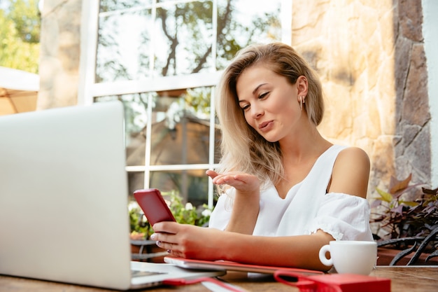 Happy woman giving air kiss during video call on mobile phone