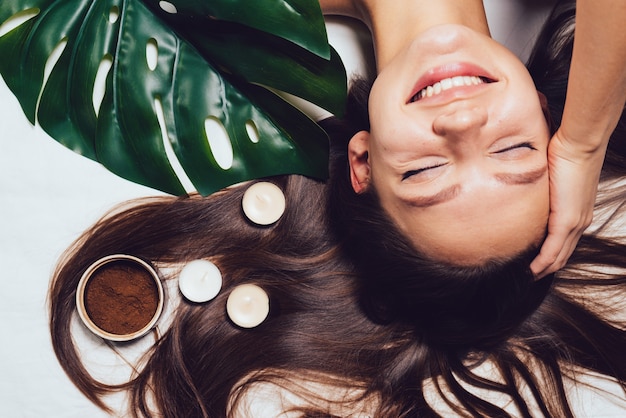 Happy woman lies after a spa treatment on a white background