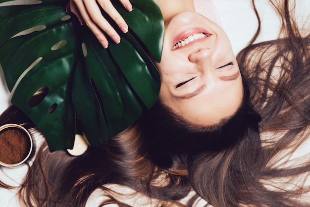 Happy woman lies after a spa treatment on a white background