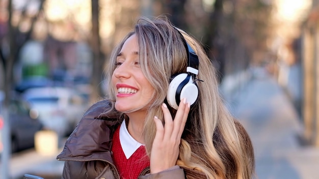 Happy woman listening to music on wireless headphones