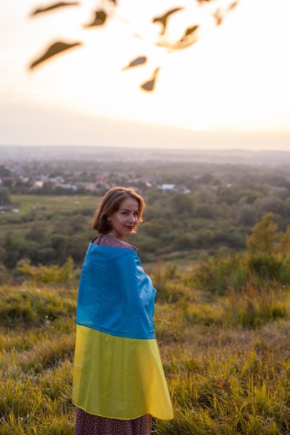 Happy Woman in long dress holding a yellow and blue flag of Ukraine