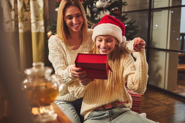 Happy woman making present for daughter on Boxing Day