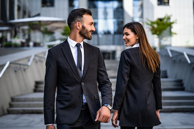 The happy woman and man walking in the business center