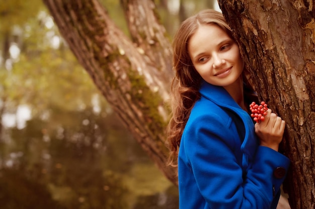 Happy woman near the river in autumn season