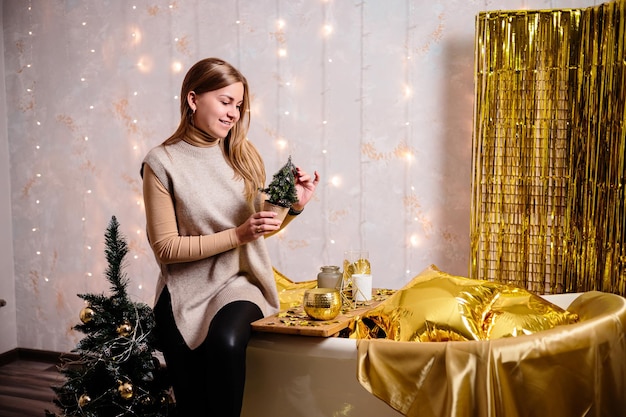 Happy woman in New Year's room New Year's decoration of the room in golden color The concept of the holiday and festive design Home decor for the New Year