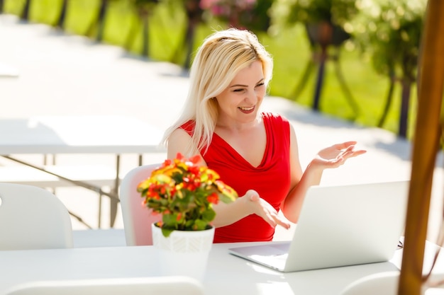 Happy woman planning vacations on line searching information in a laptop in a resort or hotel in the beach