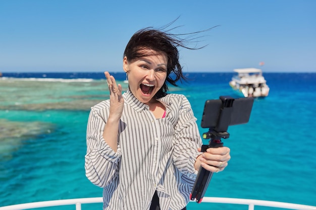 Happy woman recording video stream on smartphone background is place for diving and snorkeling