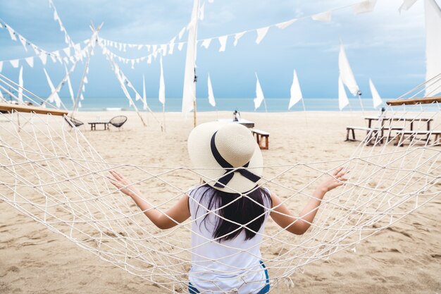 Happy woman relax in hammock on beach