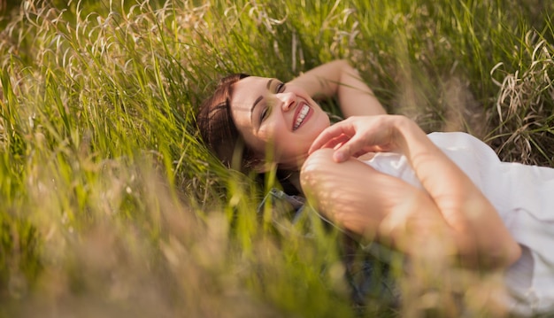 Photo happy woman relaxing in a meadow on a sunny day