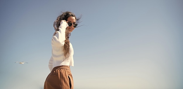 Happy woman smile looking through sunglasses on sunny sky for copy space girl