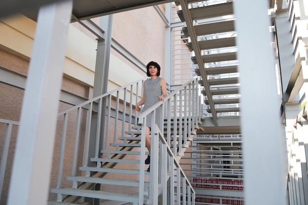 A happy woman smiling goes down the stairs after seeing a familiar person