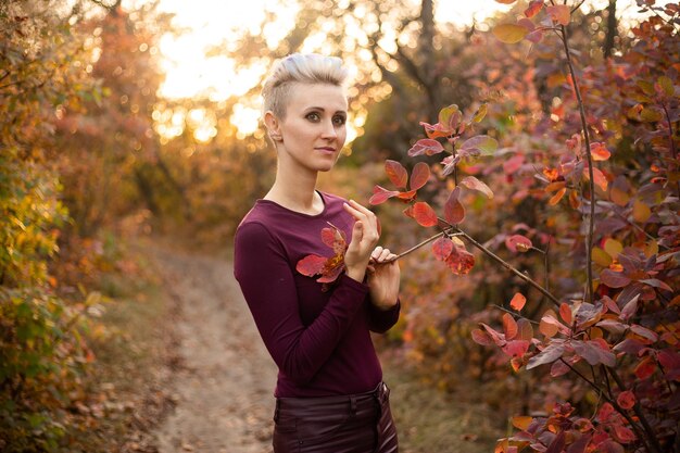 Happy woman smiling and playing with autumn leaves in park Autumn woman fall