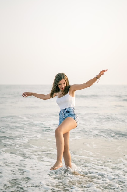 Happy woman smiling on the shore of the beach