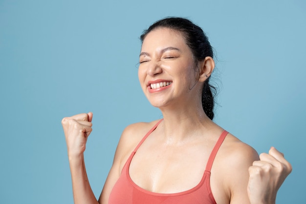 Happy woman in sportswear on blue background