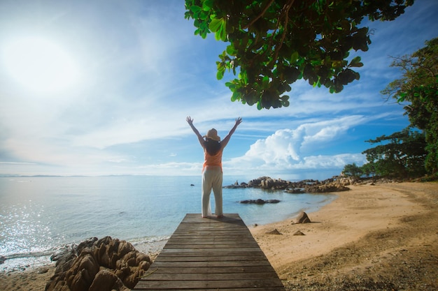 Happy woman stand on wood bridge with view of the sea soft focus with noise