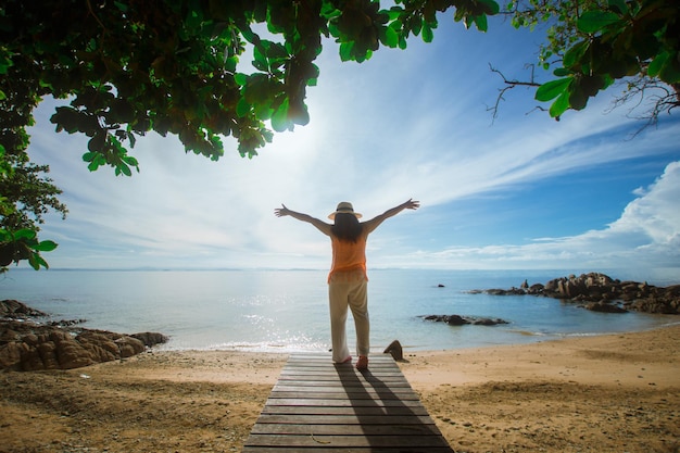 Happy woman stand on wood bridge with view of the sea soft focus with noise