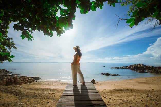 Happy woman stand on wood bridge with view of the sea soft focus with noise