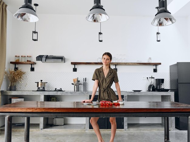 Photo happy woman standing fulllength in stylish minimalist kitchen interior with natural elements in wood