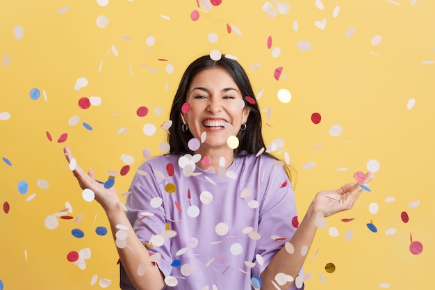 Happy woman surrounded by confetti flying in the air