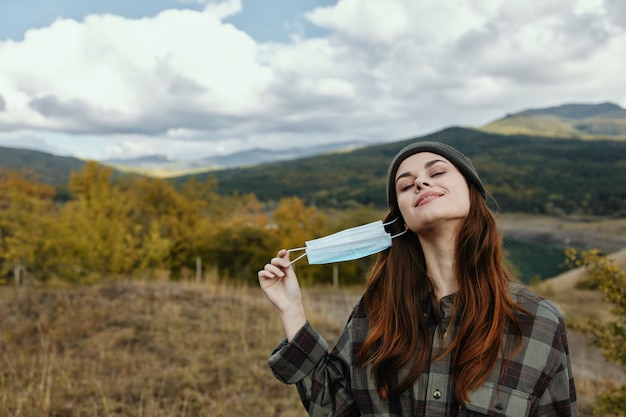 Happy woman took off the medical mask from her face in nature in the forest