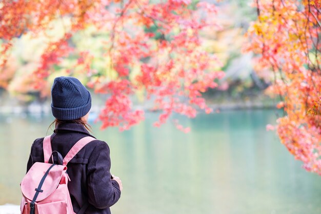 Happy woman tourist looking at colorful leaves