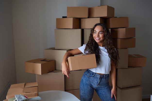 Happy woman unpacking container at home opening carton box looking inside package Smiling satisfied customer receiving parcel from order delivery service unboxing purchase