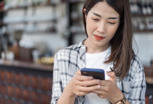 Happy woman using smartphone in cafe