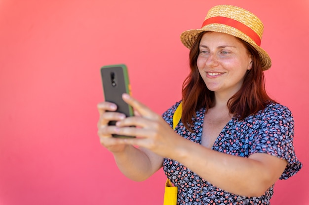 Happy woman on vacation photographing with a camera