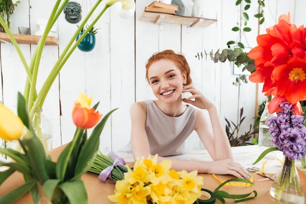 Happy woman while making bouquets in workshop