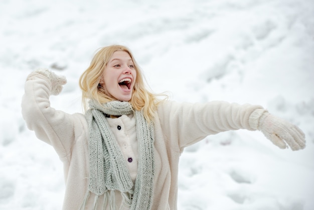 Happy woman in winter hold Snow ball. Wintertime. Snowball and winter fun. Cute playful young girl outdoor enjoying first snow.