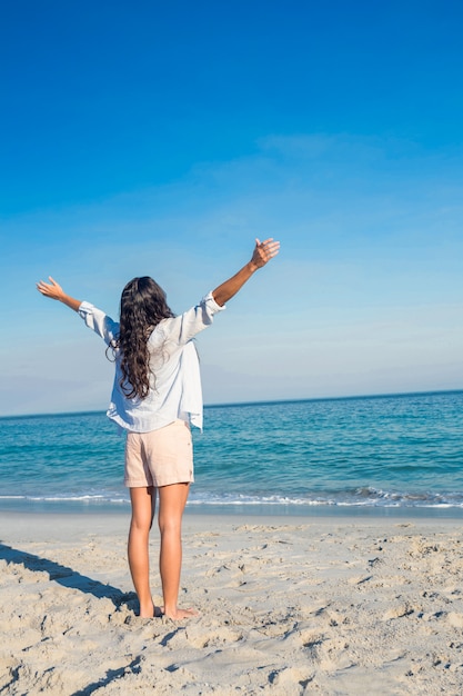 Happy woman with arms outstretched at the beach