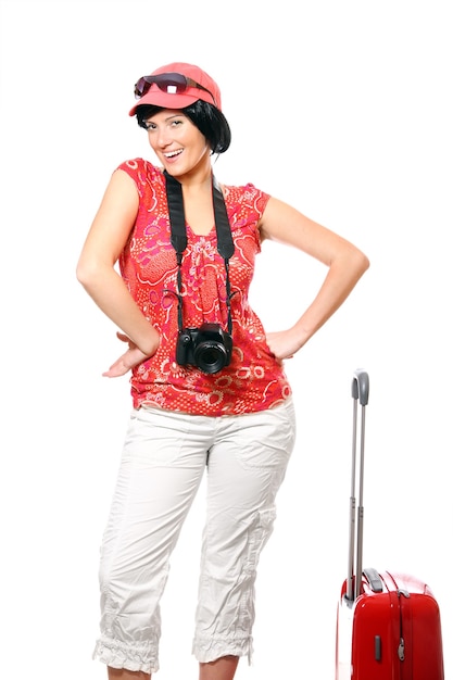 a happy woman with camera and suitcase ready to go on holidays