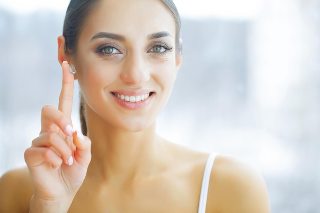 Happy Woman with Contact Lenses on the Finger